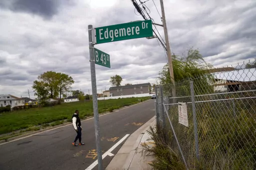 Dexter Davis, a neighborhood resident, walks the street between two abandoned residential lots 10 years after the area was severely damaged by Superstorm Sandy, Wednesday, Oct. 19, 2022, in the Edgemere neighborhood of the Queens borough of New York. There are no skateparks in Edgemere. No coffee shops. In fact, said Davis, a former NYC police officer, laments that there are few places for young people to go. "The things that they pump into the other communities around us are more positive (AP P