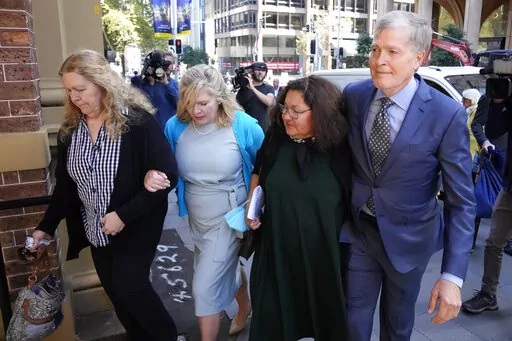 Steve Johnson, right, with his sisters, Terry, left, and Rebecca and his wife Rosemarie, second right, arrive at the Supreme Court in Sydney, Monday, May 2, 2022, for a sentencing hearing in the murder of Scott Johnson, Steve, Terry and Rebecca's brother. Scott White appeared in the New South Wales state Supreme Court for a sentencing hearing after he pleaded guilty in January to the murder of the Los Angeles-born Canberra resident Scott Johnson, whose death at the base of a North Head cliff was