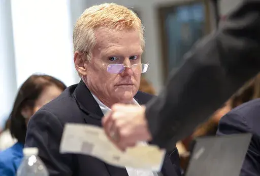 Alex Murdaugh looks over evidence of a check brought to him and his attorneys during his double murder trial at the Colleton County Courthouse on Tuesday, Feb. 7, 2023, in Walterboro, S.C. The 54-year-old attorney is standing trial on two counts of murder in the shootings of his wife and son at their Colleton County home and hunting lodge on June 7, 2021. (Andrew J. Whitaker/The Post And Courier via AP, Pool)/The Post And Courier via AP, Pool)