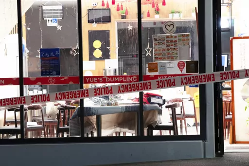 Police tape cordons off a restaurant in Auckland, New Zealand, Tuesday, June 20, 2023, after an axe attack late Monday. Multiple people were hospitalized after a man armed with an axe began attacking diners at random at three neighboring Chinese restaurants, according to police and witnesses. (Hayden Woodward/New Zealand Herald via AP)