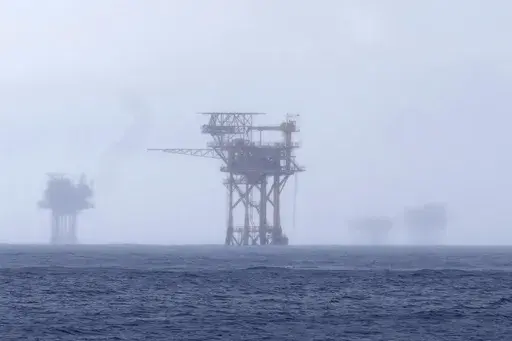 Oil platforms are visible through the haze near the Flower Garden Banks National Marine Sanctuary in the Gulf of Mexico, off the coast of Galveston, Texas, Saturday, Sept. 16, 2023. (AP Photo/LM Otero, File)