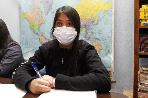 Jazmin Cazares, 14, takes notes as teacher Wendy Leighton discusses the Salem witch trials with her students at Monte del Sol Charter School, Friday, Dec. 3, 2021, in Santa Fe, N.M. Leighton is one of dozens of educators who helped draft state's proposed changes to the social studies curriculum, including adding the Sept. 11 attacks and the history of LGBTQ rights. It would increase the focus on ethnic studies in a state where 49 percent of the population is Hispanic, and 11 precent is Indigenou