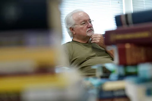 Paul Phelps, 76, of Alexandria, Va., works in the genealogy room at Hollin Hall Senior Center in Alexandria, Va., Thursday, Oct. 13, 2022. The news that 70 million people will see an 8.7% boost in their Social Security checks comes just weeks before the midterm elections, but it's unlikely to give Democrats the edge they're desperately seeking at the polls Nov. 8. (AP Photo/Susan Walsh, File)