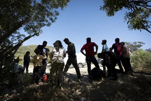 Border Patrol agents talk with migrants seeking asylum as they prepare them for transportation to be processed, June 5, 2024, near Dulzura, Calif. (AP Photo/Gregory Bull, File)