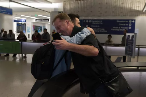 Michael White, a Navy veteran who was jailed in Iran for several years on spying charges, right, hugs Michael's former fellow prisoner and Iranian political activist Mahdi Vatankhah at the Los Angeles International Airport in Los Angeles, Thursday, June 1, 2023. Vatankhah, while in custody and after his release, helped White by providing White's mother with crucial, firsthand accounts about her son's status in prison and by passing along letters White had written while he was locked up. Once fre
