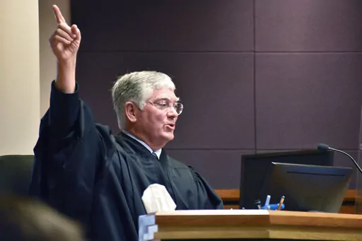 Montana District Judge Michael Moses gestures during a court hearing over a state health department rule that prevents transgender people from changing their birth certificates, Thursday, Sept. 15, 2022, in Billings, Mont. Moses struck down the rule at the conclusion of the hearing. (AP Photos/Matthew Brown)