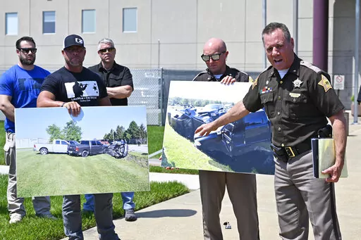 Vandenburgh County Sheriff Dave Wedding, right, refers to a photograph during a press conference in Evansville, In., Tuesday, May 10, 2022, about the capture of fugitives Casey White and Vicky White. (AP Photo/Timothy D. Easley)