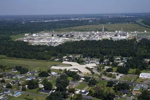 The Fifth Ward Elementary School and residential neighborhoods sit near the Denka Performance Elastomer Plant, back, in Reserve, La., Sept. 23, 2022. The EPA sued Denka Performance Elastomer LLC, arguing that its petrochemical operations in southern Louisiana posed an unacceptable cancer risk to the mostly-Black community nearby. The EPA has demanded that the company reduce toxic emissions from its plant that makes synthetic rubber. (AP Photo/Gerald Herbert, File)