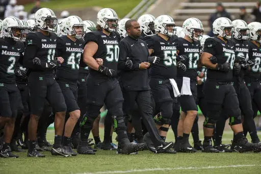Marshall players and coaches take the field against UAB in an NCAA college football game on Saturday, Nov. 13, 2021, at Joan C. Edwards Stadium in Huntington W.Va. On Tuesday, March 29, 2022, Conference USA announced in a joint statement with Marshall, Old Dominion and Southern Miss that it has reached a resolution with the three schools to expedite their early move to the Sun Belt. (Sholten Singer/The Herald-Dispatch via AP, File)