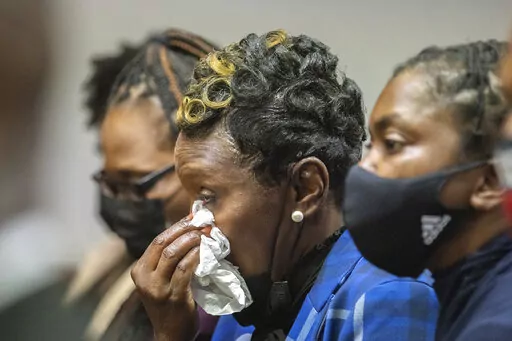Ahmaud Arbery's mother Wanda Cooper-Jones, center, reacts as Superior Court Judge Timothy Walmsley sentences Greg McMichael, his son, Travis McMichael, and a neighbor, William "Roddie" Bryan in the Glynn County Courthouse, Friday, Jan. 7, 2022, in Brunswick, Ga. The three white men who chased and killed Ahmaud Arbery were sentenced Friday to life in prison, with a judge denying any chance of parole for the father and son who armed themselves and initiated the deadly pursuit of Arbery, a 25-year-