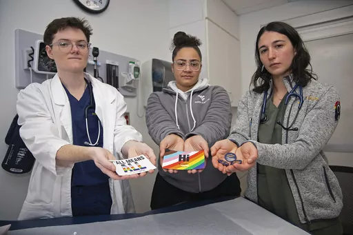 West Virginia University students El Didden, Bri Caison and Lia Farrell hold materials from the Rainbow Coats on Wednesday, March 8, 2023, in Morgantown, W.Va. (AP Photo/Kathleen Batten)