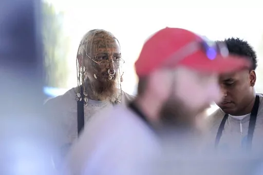 Cyrus Collins, left, an aspiring Minneapolis police officer, works his part-time job as a cook at The Blue Barn during the Minnesota State Fair, on Sept. 3, 2022, in Falcon Heights, Minn. Collins was among a handful of people at a recent Minneapolis Police Department recruiting session as the department seeks to rebuild its ranks following the departure of hundreds of officers in the wake of George Floyd's killing. (AP Photo/Abbie Parr)