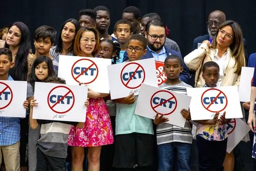 Kids holding signs against Critical Race Theory stand on stage near Florida Gov. Ron DeSantis as he addresses the crowd before publicly signing HB7 at Mater Academy Charter Middle/High School in Hialeah Gardens, Fla., on April 22, 2022. Republican groups that sought to get hundreds of “parents’ rights” activists elected to local school boards largely fell short in Tuesday’s elections. The push has been boosted by Republican groups including the 1776 Project PAC, but just a third of its r