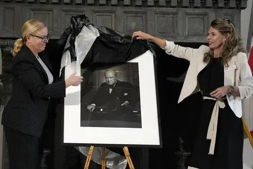 Canadian Cultural Heritage Deputy Minister, Isabelle Mondou, left, and Andrea Clark-Grignon, Head of Public Affairs, unveil a photographic portrait known as 'The Roaring Lion', taken by photographer Yousuf Karsh in 1941 of Britain's Prime Minister Winston Churchill, stolen in Canada in 2022, and returned during a ceremony at the Canada's embassy in Rome, Thursday, Sept. 19, 2024. (AP Photo/Alessandra Tarantino)