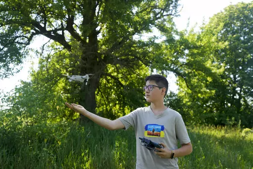Andriy Pokrasa, 15, lands his drone on his hand during an interview with The Associated Press in Kyiv, Ukraine, Saturday, June 11, 2022. Andriy is being hailed in Ukraine for stealthy aerial reconnaissance work he has done with his dad in the ongoing war with Russia. They used their drone to help the country's military spot, locate and destroy Russian targets in the early days of the Russian invasion. (AP Photo/Natacha Pisarenko)