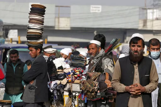 Street vendors wait for customers along a road in old area of Peshawar, Pakistan, Wednesday, Feb. 1, 2023. Peshawar, a key mountain valley connecting South and Central Asia, was once known as "the city of flowers," surrounded by orchards of pear, quince, and pomegranate trees. But for the past four decades, it has borne the brunt of rising militancy in the region, fueled by the conflicts in neighboring Afghanistan. (AP Photo/Muhammad Sajjad)