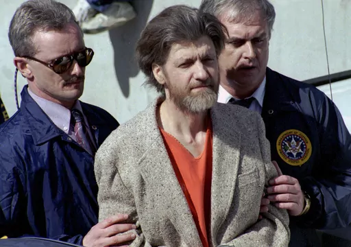 Theodore "Ted" Kaczynski is flanked by federal agents as he is led to a car from the federal courthouse in Helena, Mont., April 4, 1996. Kaczynski, known as the “Unabomber,” who carried out a 17-year bombing campaign that killed three people and injured 23 others, died by suicide, four people familiar with the matter told The Associated Press, Sunday, June 11, 2023. (AP Photo/John Youngbear, File)