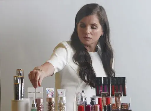 Revlon CEO Debra Perelman, the company's first woman CEO in its 89-year-old history, show products during an interview, Wednesday Aug. 18, 2021, in New York. Revlon, the 90-year-old multinational beauty company, has filed for Chapter 11 bankruptcy protection, Thursday, June 16, 2022, weighed down by debt load, disruptions to its supply chain network and surging costs.  (AP Photo/Bebeto Matthews, File)