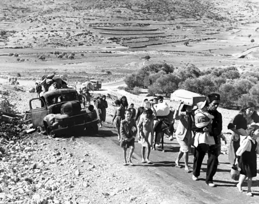 A group of Arab refugees walks along a road from Jerusalem to Lebanon, carrying their belongings with them on Nov. 9, 1948. The group was driven from their homes by attacks in Galilee. For the first time, the United Nations will officially commemorate the flight of hundreds of thousands of Palestinians from what is now Israel on the 75th anniversary of their exodus, an action stemming from the U.N.’s partition of British-ruled Palestine into separate Jewish and Arab states. (AP Photo/Jim Pring