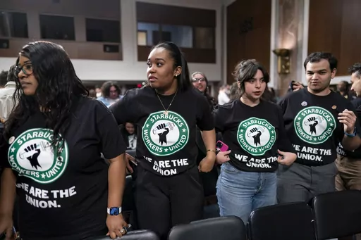 Advocates for a union for Starbucks employees watch as company founder Howard Schultz leaves a hearing after testifying to the Senate Health, Education, Labor and Pensions Committee at the Capitol in Washington on March 29, 2023. Starbucks has been accused of chilling organization by closing unionized stores and firing pro-union workers. (AP Photo/J. Scott Applewhite, File)