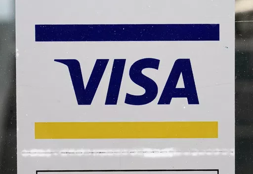 A Visa sign is displayed on the front door of a local business, April 27, 2021, in Urbandale, Iowa. Visa has announced major changes to how its credit and debit cards will operate in the U.S. Features in the works will lead to Americans to carry fewer physical cards in their wallets and make the 16-digit credit or debit card number printed on every physical card increasingly irrelevant. The new features unveiled Wednesday, May 15, 2024 will be some of the biggest changes to how payments operate 