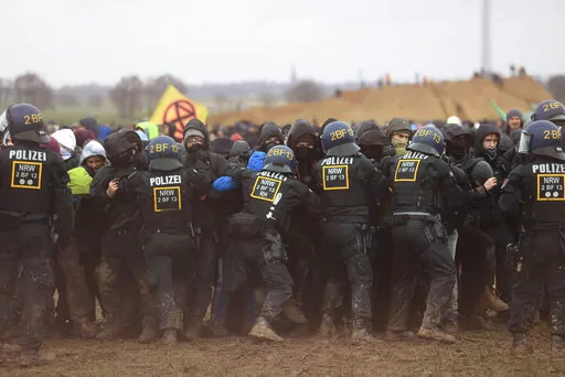 Police officers push back demonstrators on the edge of the opencast lignite mine Garzweiler at the village Luetzerath near Erkelenz, Germany, Saturday, Jan. 14, 2023. ( Oliver Berg/dpa via AP)