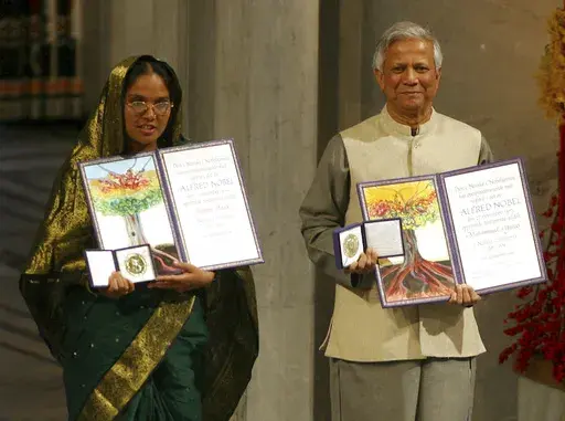 FILE- Nobel Peace Prize winners Muhammad Yunus, right, and Grameen Bank representative Mosammat Taslima Begum display their medals and diplomas at City Hall in Oslo, Norway Sunday Dec. 10, 2006. (AP Photo/John McConnico, File)