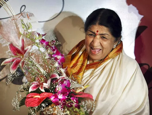 FILE- Singer Lata Mangeshkar laughs at the launch of her hindi music album 'Saadgi' or Simplicity, on World Music Day, in Mumbai, India, Thursday, June 21, 2007.  Lata Mangeshkar, legendary Indian singer with a voice recognized by a billion people in South Asia, has died at 92. (AP Photo/Rajesh Nirgude, File)(AP Photo/Rajesh Nirgude, file)