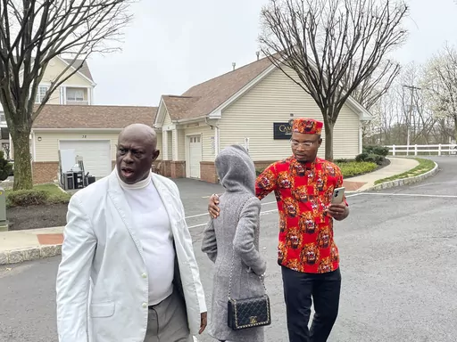 From left, Prince Dwumfour, Nicole Teliano and Peter Ezechukwu walk near the scene of the fatal shooting of their family member, Eunice Dwumfour, in Sayreville, N.J., April 5, 2023. Eunice Dwumfour, a Sayreville council member, was gunned down Feb. 1 as she arrived home in Sayreville. (AP Photo/Maryclaire Dale)