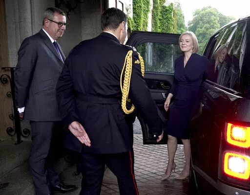 Newly elected leader of the Conservative party Liz Truss  is greeted by Queen Elizabeth II's Equerry Lieutenant Colonel Tom White and her Private Secretary Sir Edward Young as she arrives at Balmoral for an audience with Queen Elizabeth II where she will be invited to become Prime Minister and form a new government, in Aberdeenshire, Scotland, Tuesday, Sept. 6, 2022. (Andrew Milligan/Pool Photo via AP)