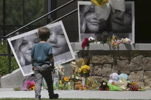 A boy looks at a memorial for Tylee Ryan and Joshua "JJ" Vallow in Rexburg, Idaho, on June 11, 2020. A mother charged with murder in the deaths of her two children is set to stand trial in Idaho. The proceedings against Lori Vallow Daybell beginning Monday, April 3, 2023, could reveal new details in the strange, doomsday-focused case. (John Roark/The Idaho Post-Register via AP, File)