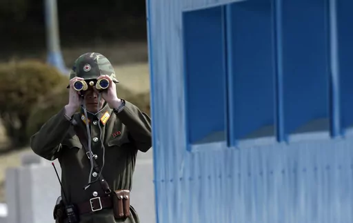 A North Korean soldier looks at the southern side through a pair of binoculars at the border village of the Panmunjom, in the Demilitarized Zone, DMZ, that separates the two Koreas since the Korean War, in Paju, north of Seoul, South Korea, Tuesday, March 19, 2013. A series of low-slung buildings and somber soldiers dot the landscape of the DMZ, the swath of land between North and South Korea where a soldier on a tour crossed into North Korea on Tuesday, July 18, 2023, under circumstances that r