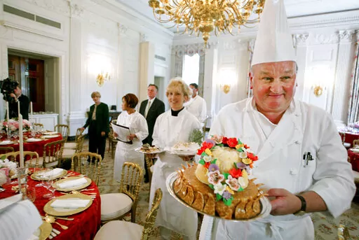 White House pastry chef Roland Mesnier, right, displays a mango coconut lei, the dessert for the dinner hosted by President George W. Bush for Philippine President Gloria Macapagal Arroyo, in the State Dining Room in the White House in Washington, May 19, 2003. Mesnier, a White House executive chef and who served five presidential administrations for roughly 25 years, died Friday, Aug. 26, 2022. (AP Photo/Charles Dharapak, File)
