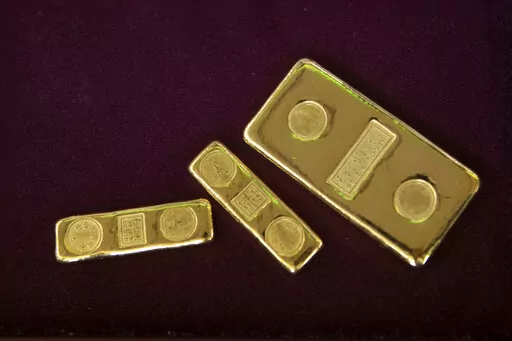 A customer puts gold bars in basket for to sell at a gold shop in Bangkok, Thailand, April 16, 2020. Russia appears to have defaulted on its foreign debt for the first time since the 1917 Bolshevik Revolution, and the U.S. and its allies are taking aim at the former Soviet Union's second-largest export industry after energy — gold. (AP Photo/Sakchai Lalit, File)