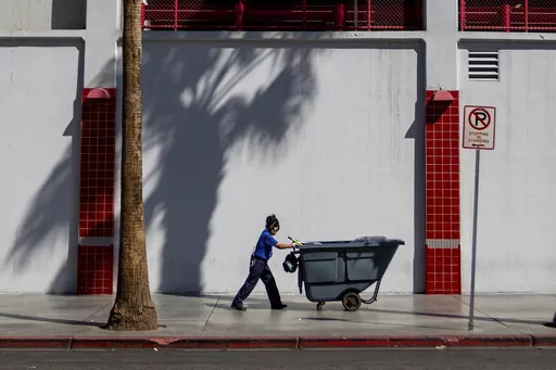 A maintenance worker pushes a refuse cart in the sun, Friday, Aug. 25, 2023, in Las Vegas. A historic heat wave that began blasting the Southwest and other parts of the country this summer is shining a spotlight on one of the harshest, yet least-addressed, effects of climate change in the U.S.: the rising deaths and injuries of people who work in extreme heat, whether inside hot warehouses and kitchens or outside under the blazing sun. Many of them are migrants in low-wage jobs. (AP Photo/Ty O'N