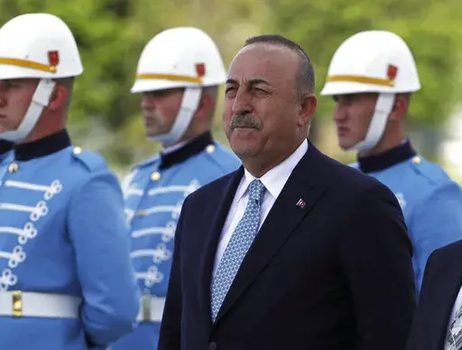 Turkish Foreign Minister Mevlut Cavusoglu stands with a military honour guard, in Ankara, Turkey, Wednesday, June 1, 2022. Cavusoglu sent a letter to the U.N. formally requesting that his country be referred to as "Türkiye," the state-run news agency reported. The move is seen as part of a push by Ankara to rebrand the country and dissociate its name from the bird, turkey, and some negative connotations that are associated with it. Anadolu Agency said Stephane Dujarric, spokesman to U.N. Secret