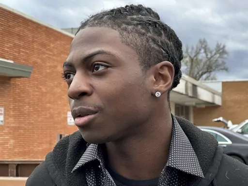 Darryl George, an 18-year-old high school junior, stands outside a courthouse in Anahuac, Texas, on Wednesday, Jan. 24, 2024. A judge ordered Wednesday that a trial be held next month to determine whether George can continue being punished by his district for refusing to change a hairstyle he and his family say is protected by a new state law. (AP Photo/Juan A. Lozano)