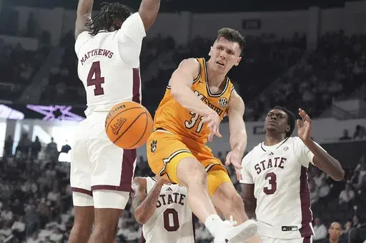 Missouri guard Caleb Grill (31) passes the ball around Mississippi State forward Cameron Matthews (4) during the first half of an NCAA college basketball game, Saturday, Feb. 1, 2025, in Starkville, Miss. (AP Photo/Rogelio V. Solis)
