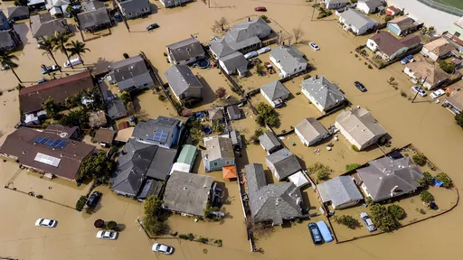 Floodwaters surround homes and vehicles in the community of Pajaro in Monterey County, Calif., March 13, 2023. An overwhelming majority of the U.S. public say they have recently experienced extreme weather, and most of them attribute that to climate change, according to a new poll from The Associated Press-NORC Center for Public Affairs Research. (AP Photo/Noah Berger)