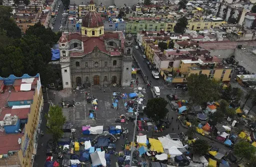 An aerial view of a migrant tent encampment set up on the plaza of the Santa Cruz y La Soledad Catholic parish church, in La Merced neighborhood of Mexico City, Dec. 26, 2023. (AP Photo/Marco Ugarte, File)