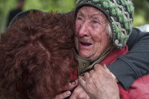 Tetiana, 82, cries with her daughter as she is evacuated from Vovchansk, Ukraine, Saturday, May 11, 2024. Her husband was killed in their house after a Russian airstrike on the city. (AP Photo/Evgeniy Maloletka)