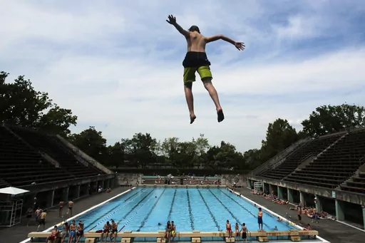A boy jumps into the water at the Olympic open air public pool in Berlin, Germany, May 21, 2014. Women in Berlin will soon be allowed to go topless at the city's public pools, the Berlin state government said Thursday. The new bathing rules to allow both men and women to go swimming without covering their upper bodies came in reaction to a woman's complaint alleging discrimination because she was not allowed to swim topless in a swimming pool in Berlin, like men. (AP Photo/Markus Schreiber, File
