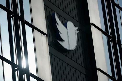 A Twitter logo hangs outside the company's offices in San Francisco, on Dec. 19, 2022. William Shatner, Monica Lewinsky and other prolific Twitter commentators — some household names, others little-known journalists — could soon be losing the blue check marks that helped verify their identity on the social media platform. (AP Photo/Jeff Chiu, File)