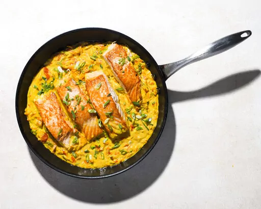 This image released by Milk Street shows a recipe for Salmon in Coconut-Curry Sauce. (Milk Street via AP)