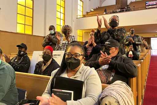People applaud chair Kamilah Moore during a reparations task force meeting at Third Baptist Church in San Francisco, Wednesday, April 13, 2022. California's first-in-the-nation reparations task force met for the first time since its inaugural meeting nearly a year ago. The live meeting also comes mere weeks after the group voted to limit restitution to descendants of enslaved or free Black people in the U.S. before the 20th century. (AP Photo/Janie Har)