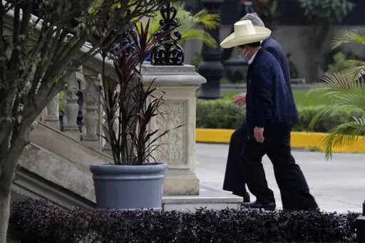 President-elect Pedro Castillo walks with interim President Francisco Sagasti at the government palace before a transition meeting, in Lima, Peru, Wednesday, July 21, 2021. Turmoil in Peru's government is boiling after President Pedro Castillo overhauled his Cabinet ton Jan. 22, for a third time in six months and then it quickly emerged his new prime minister has faced domestic violence claims. (AP Photo/Gudalupe Pardo, File)