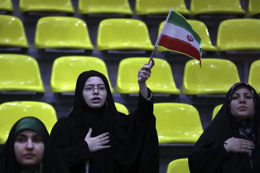 Iranian women listen to their country's national anthem as one of them waves the national flag during an election campaign rally ahead of the March 1, parliamentary and Assembly of Experts elections, in Tehran, Iran, Tuesday, Feb. 27, 2024. Iran is holding parliamentary elections this Friday, yet the real question may not be who gets elected but how many people actually turn out to vote. Separately, Iranians will also vote on Friday for members of the country's 88-seat Assembly of Experts, an ei