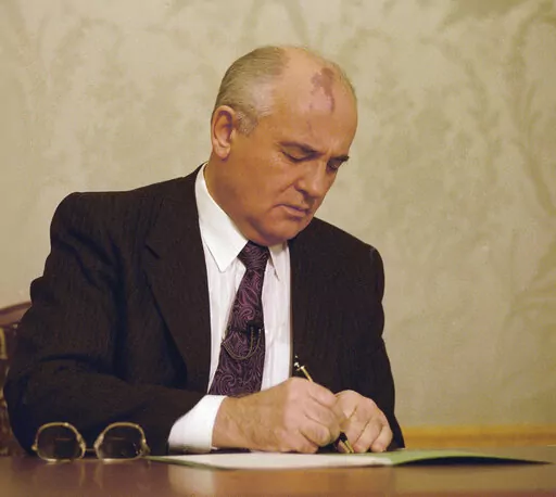 FILE - Mikhail Gorbachev, the final leader of the Soviet Union, signs the decree relinquishing control of nuclear weapons to Boris Yeltsin at the Kremlin in Moscow, Wednesday, Dec. 25, 1991. Gorbachev announced his resignation in a live televised address to the nation on Dec. 25, 1991, drawing a line under more than 74 years of Soviet history. By the fall of 1991, however, deepening economic woes and secessionist bids by Soviet republics had made the collapse of the USSR all but inevitable. The 