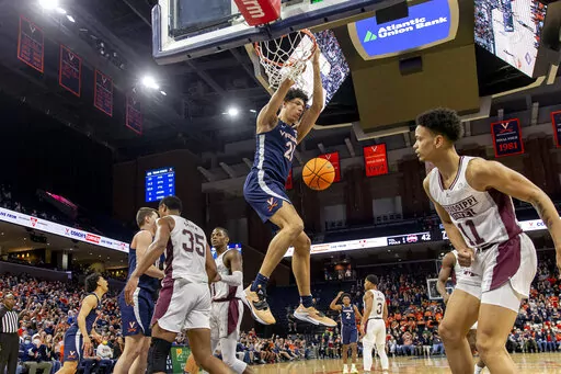 Virginia forward Kadin Shedrick (21) hangs from the basket after a dunk during the second half against Mississippi State in an NCAA college basketball game in the first round of the NIT, Wednesday, March 16, 2022, in Charlottesville, Va. (Erin Edgerton/The Daily Progress via AP)