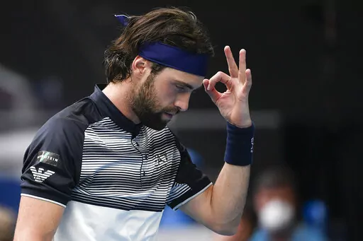 Nikoloz Basilashvili of Georgia gestures during his first round match against Andy Murray of Britain at the Australian Open tennis championships in Melbourne, Australia, Tuesday, Jan. 18, 2022.  On Friday, Jan. 21, The Associated Press reported on stories circulating online incorrectly claiming three tennis players,  Basilashvili, Nick Kyrgios and Dalila Jakupovic — were forced to drop out of this year’s Australian Open after they experienced chest-related health issues.(AP Photo/Andy Brownb